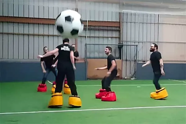 Joueurs de crazy foot avec d'énormes chaussures gonflables